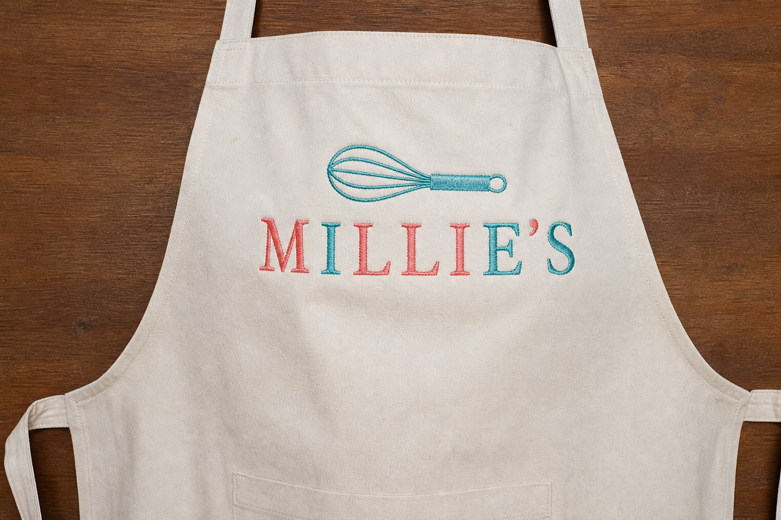 Machine-embroidered bakery name on a kitchen apron